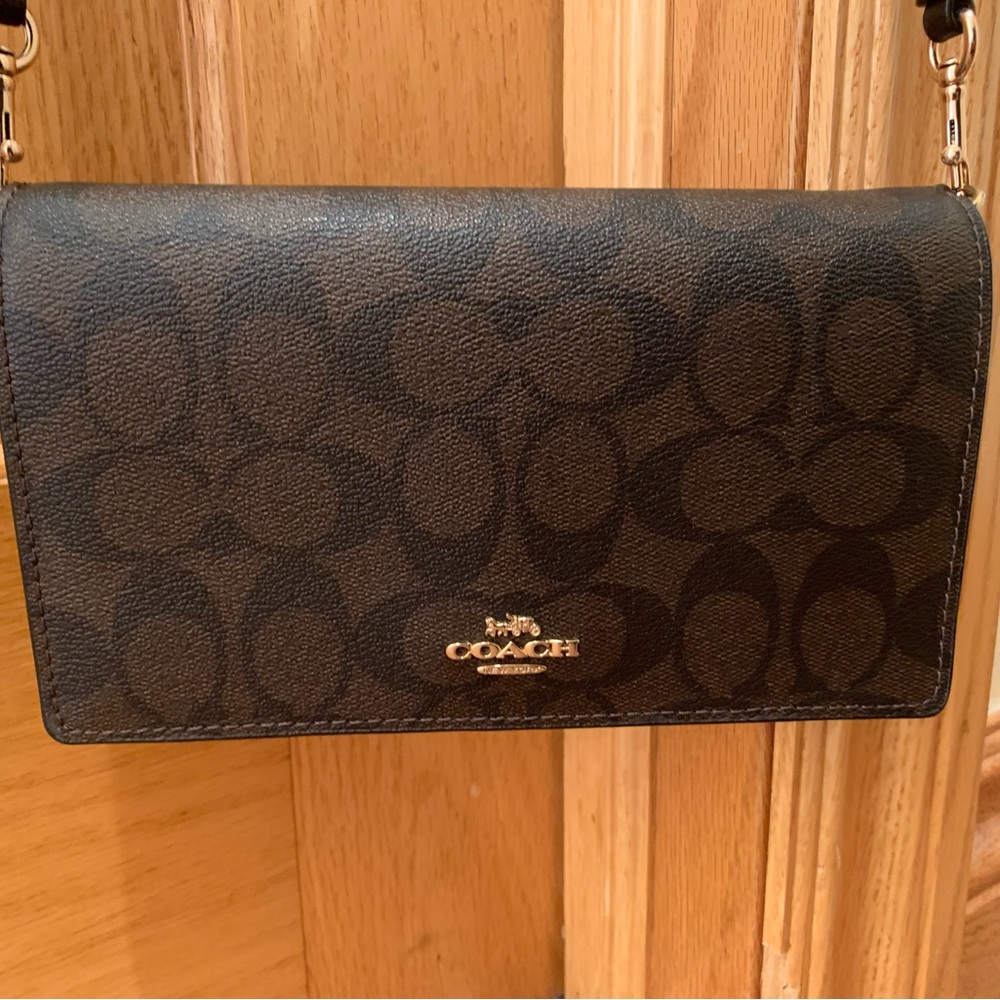 Coach fold over clutch / crossbody sleek bag. Colors are brown and black.